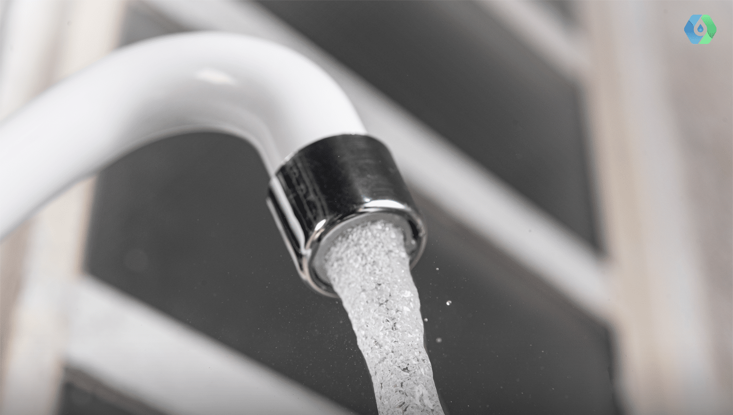 Close-up of a modern kitchen faucet with water flowing out, illustrating the ready availability of hot water in a home.
